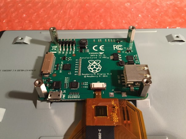 Screw in the standoff posts to hold the display controller card to the display. Connect the display and touchscreen wires as described on the official installation guide.