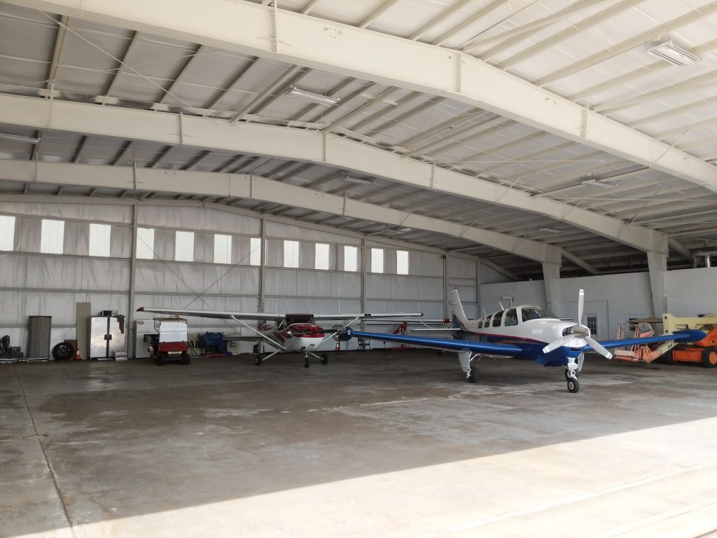 Cessna and Beechcraft Bonanza parked in a hanger at St. Simons Island Airport at McKinnon Field, May 2019.
