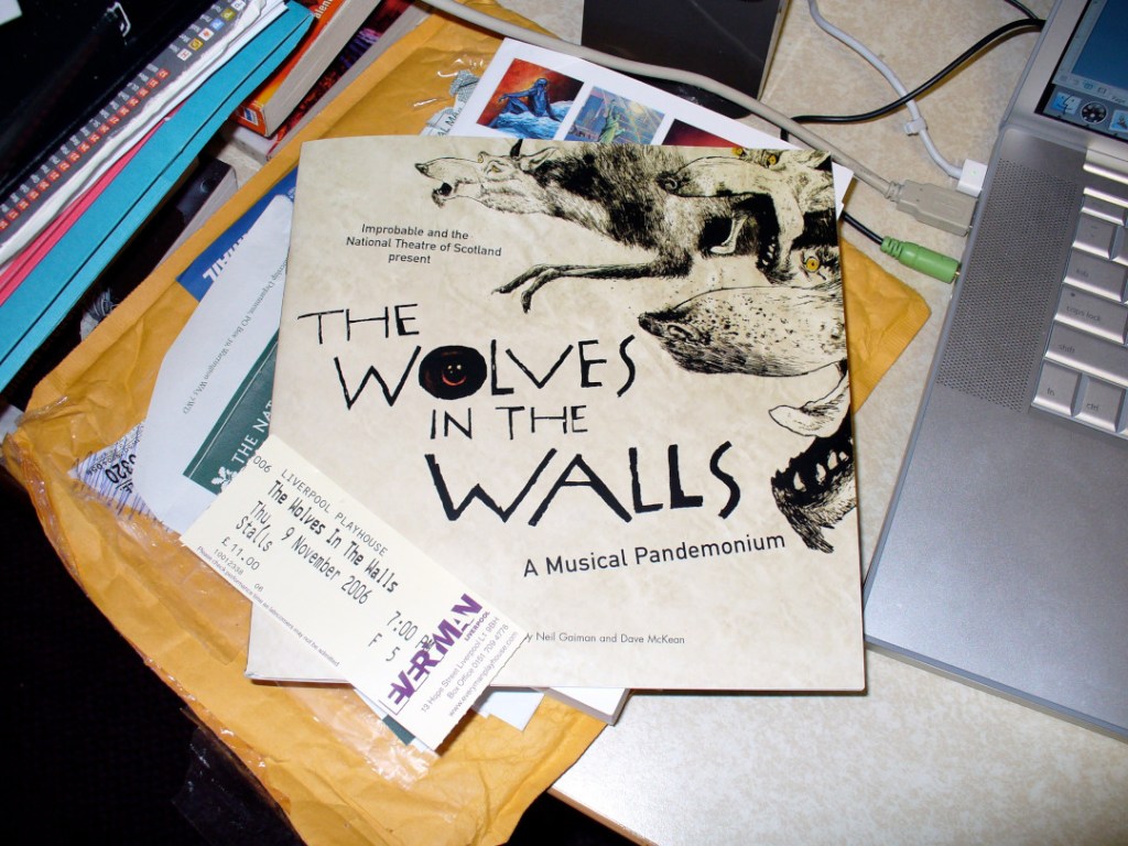Program book and ticket for "The Wolves in the Walls" stage adaptation of the book by Neil Gaiman and DAve McKean. Messy desk in the background.