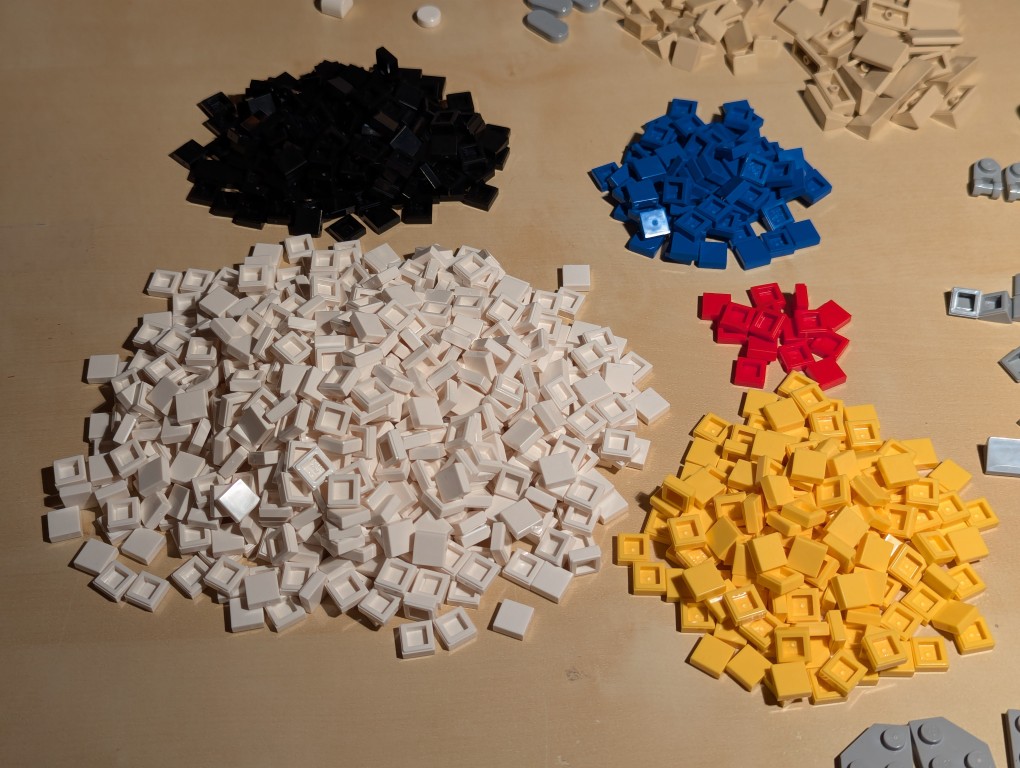 5 piles of 1x1 LEGO flat tiles in different colors