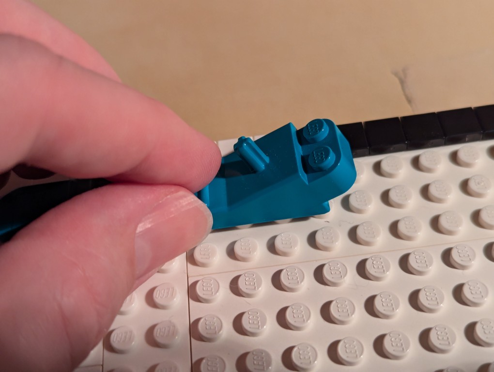 LEGO brick separator sliding along the 1x1 flat tiles to align them