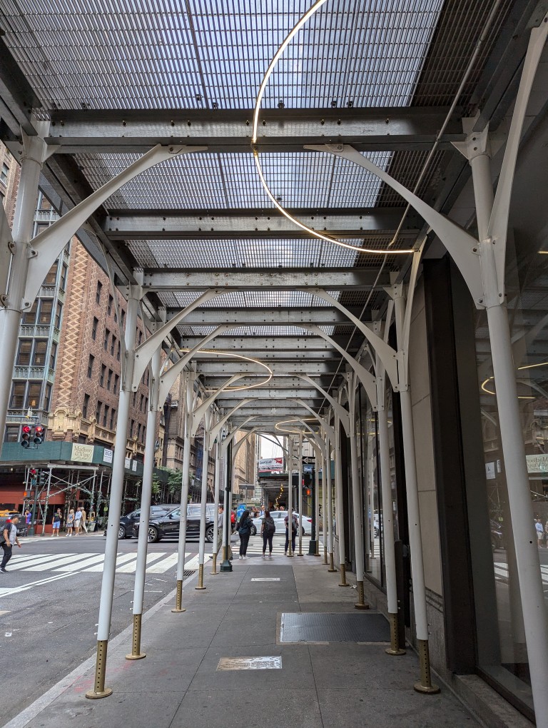 NYC sidewalk covered with scaffolding and semicircular lights