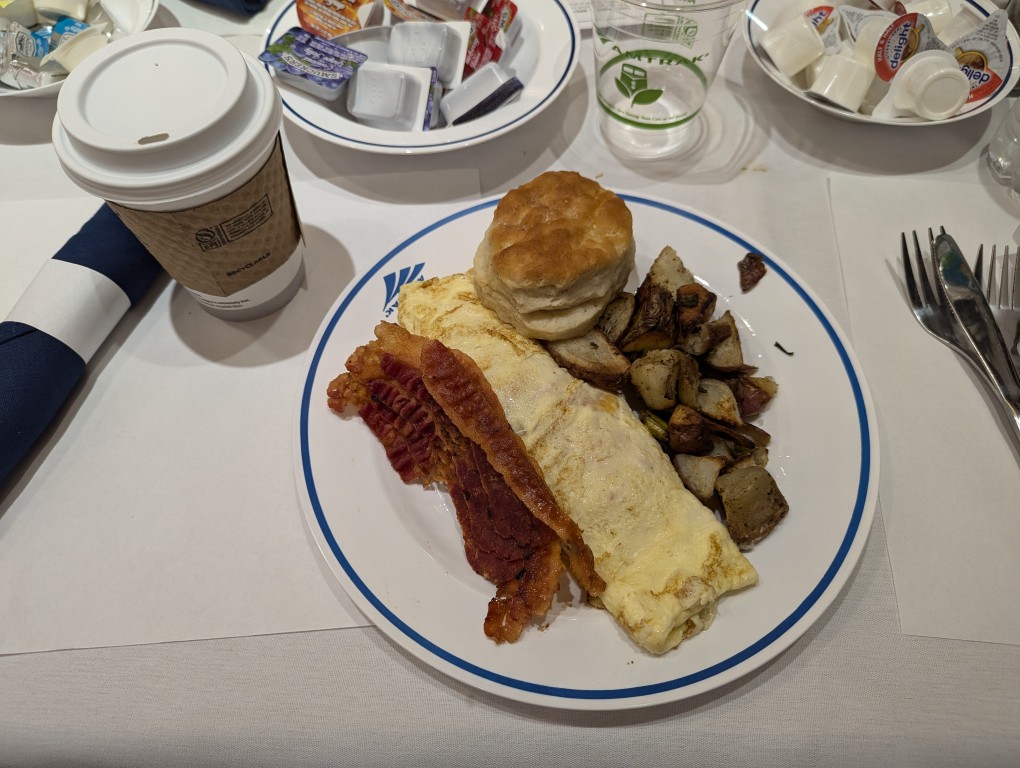amtrak dining car breakfast of omelette, bacon, potatoes, and biscuit on a table with white tablecloth