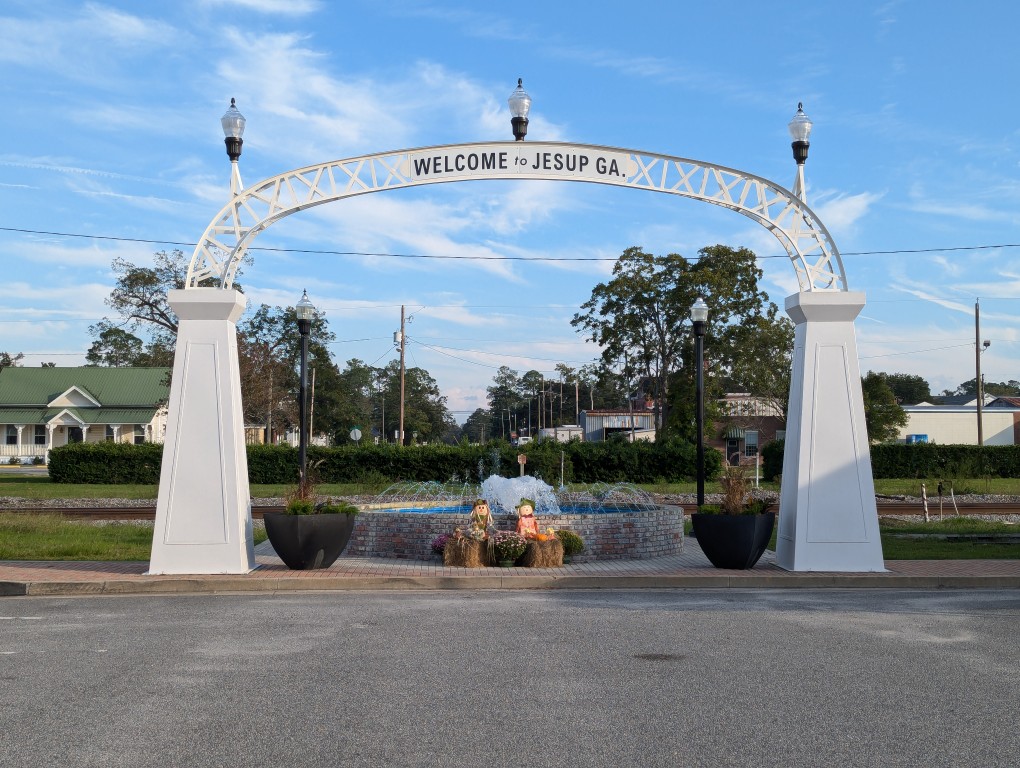 welcome to jesup georgia arch and fountain in front of train tracks