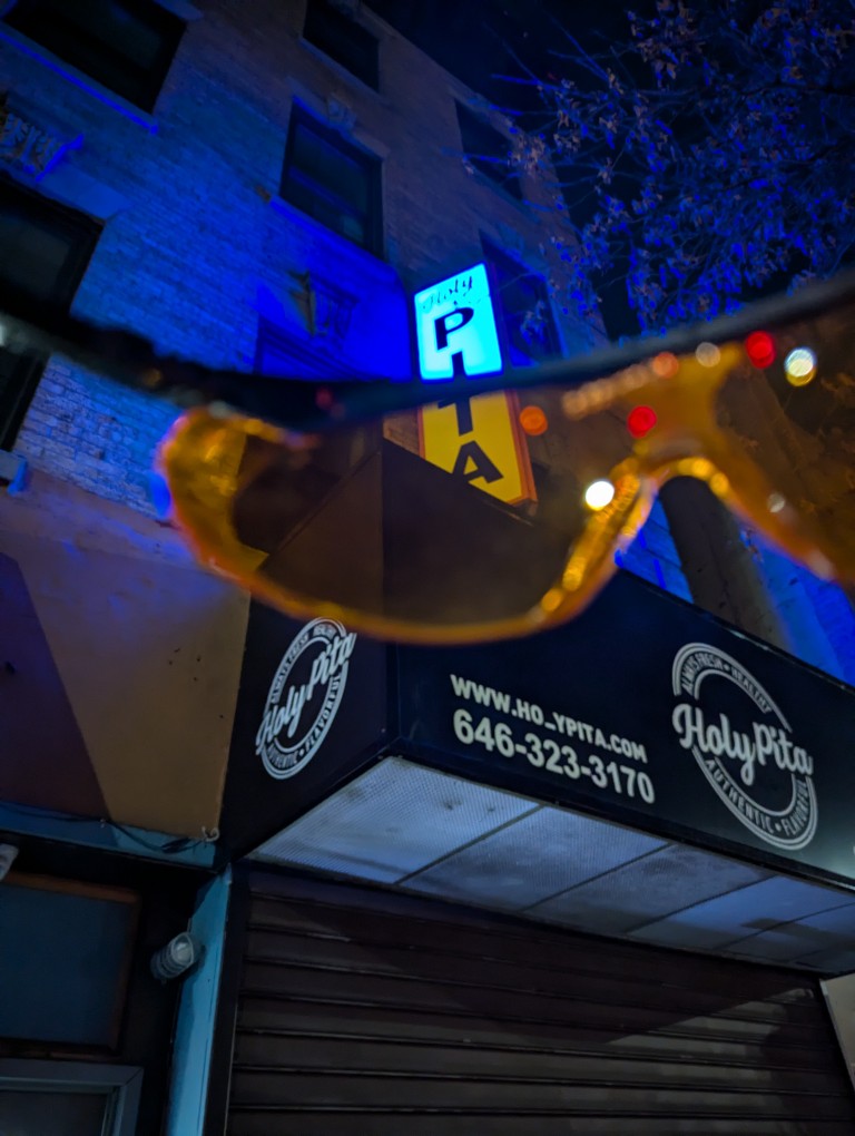 the orange glasses' lens turns a blue sign orangish white