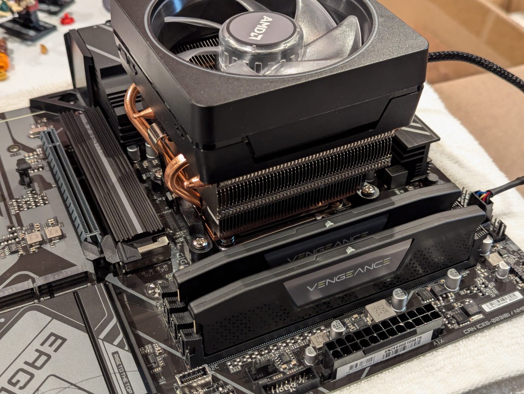 2 sticks of ddr5 ram installed on a motherboard next to cpu and cpu cooler
