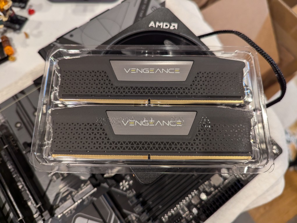 2 sticks of DDR5 memory in a plastic case sitting on top of a motherboard