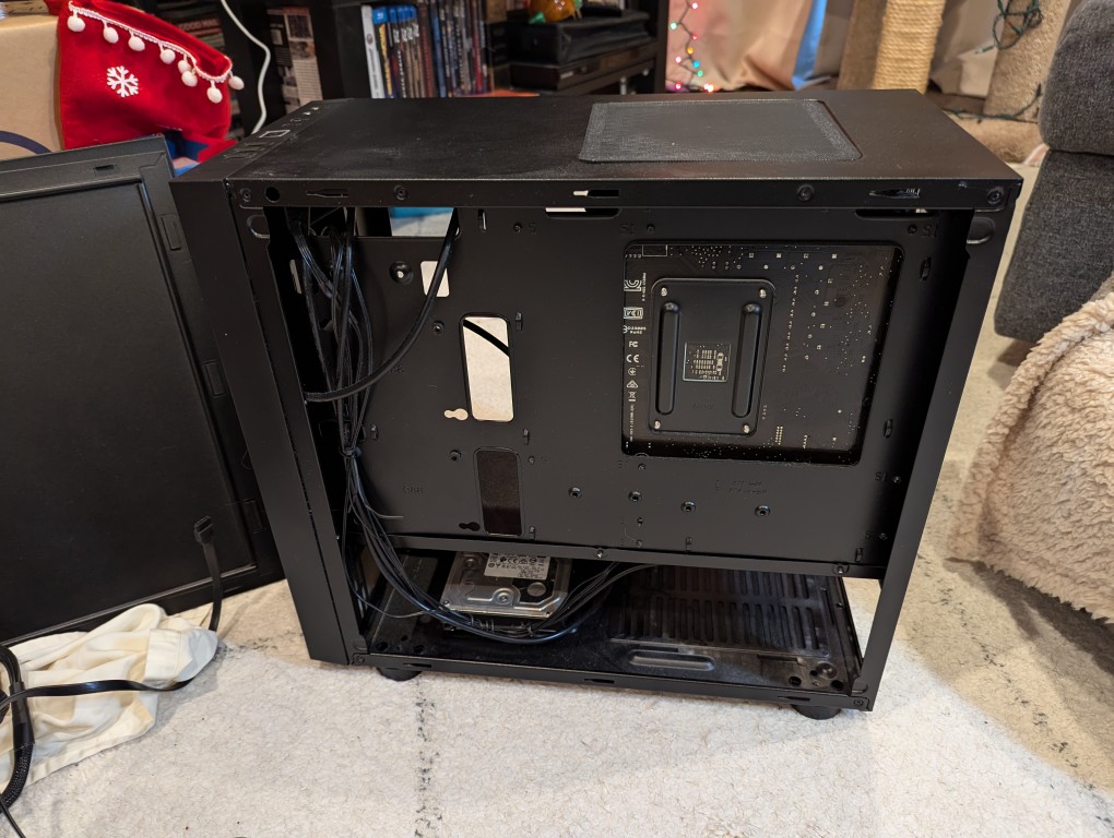 micro atx case with back side panel removed revealing cables and hard drives