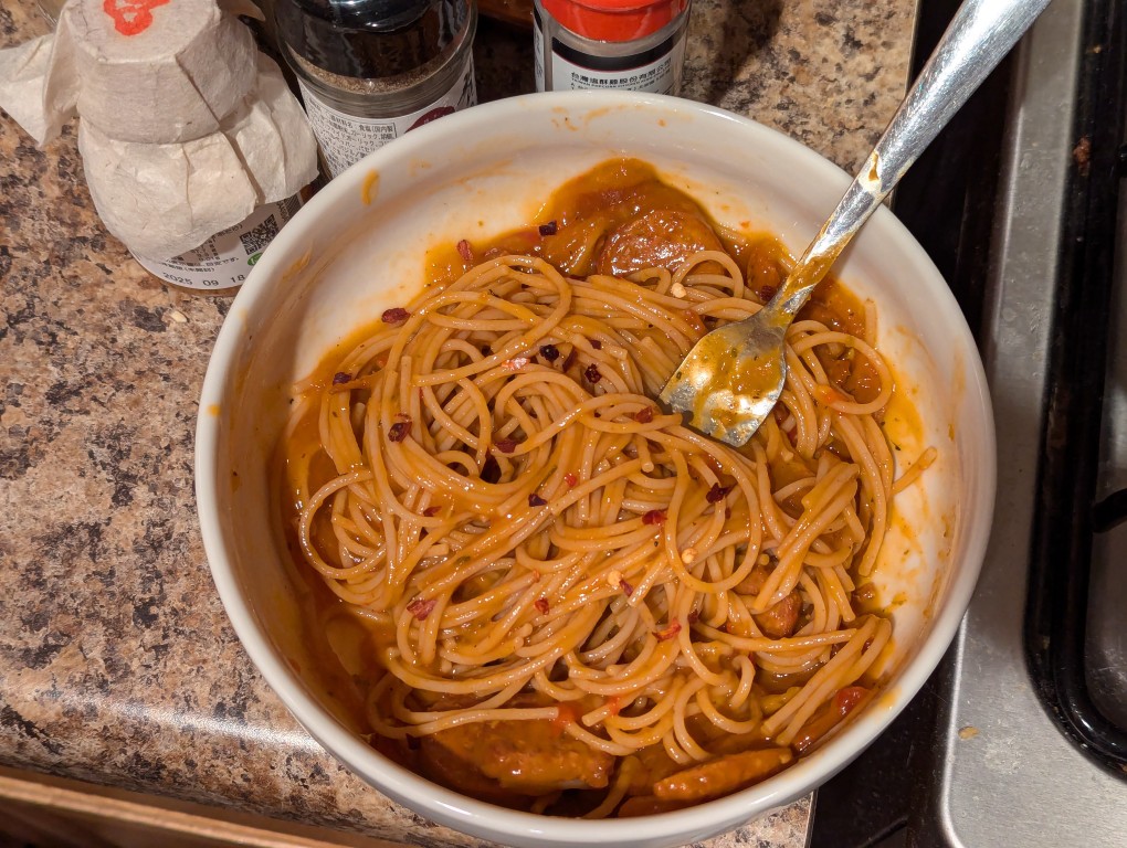 bowl of italian sausage in sauce with noodles