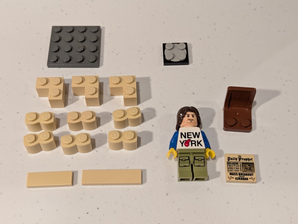 a lego mini figure sitting and reading in a tiny corner made out of bricks deconstructed