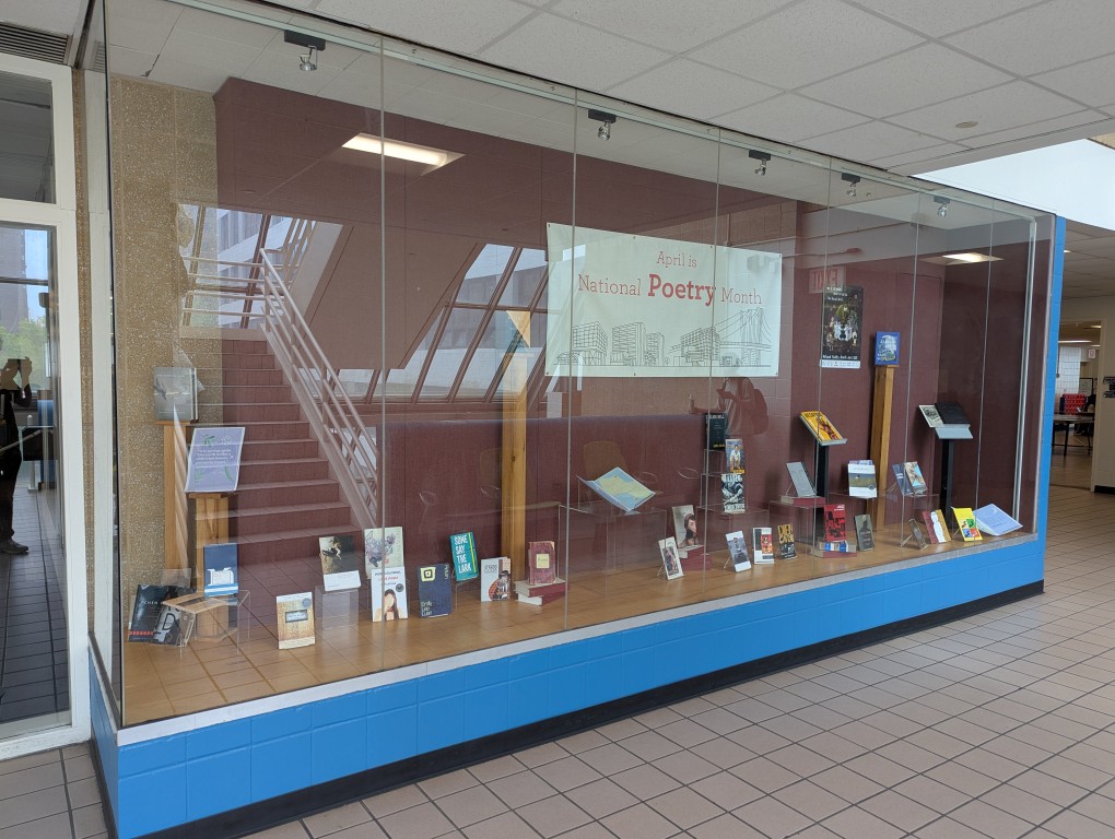 display of books and banner for national poetry month behind a large glass facade