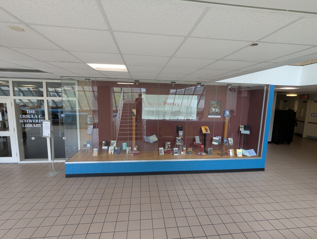 display of books and banner for national poetry month behind a large glass facade