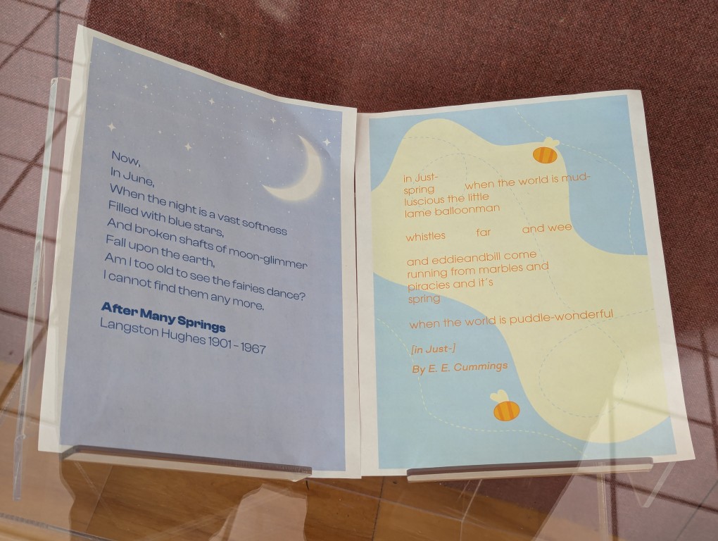 display of books and banner for national poetry month behind a large glass facade