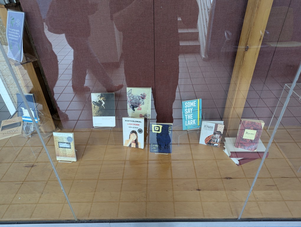 display of books and banner for national poetry month behind a large glass facade