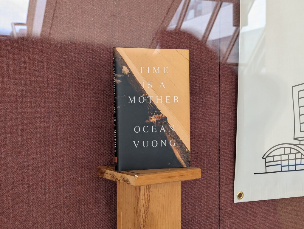 display of books and banner for national poetry month behind a large glass facade