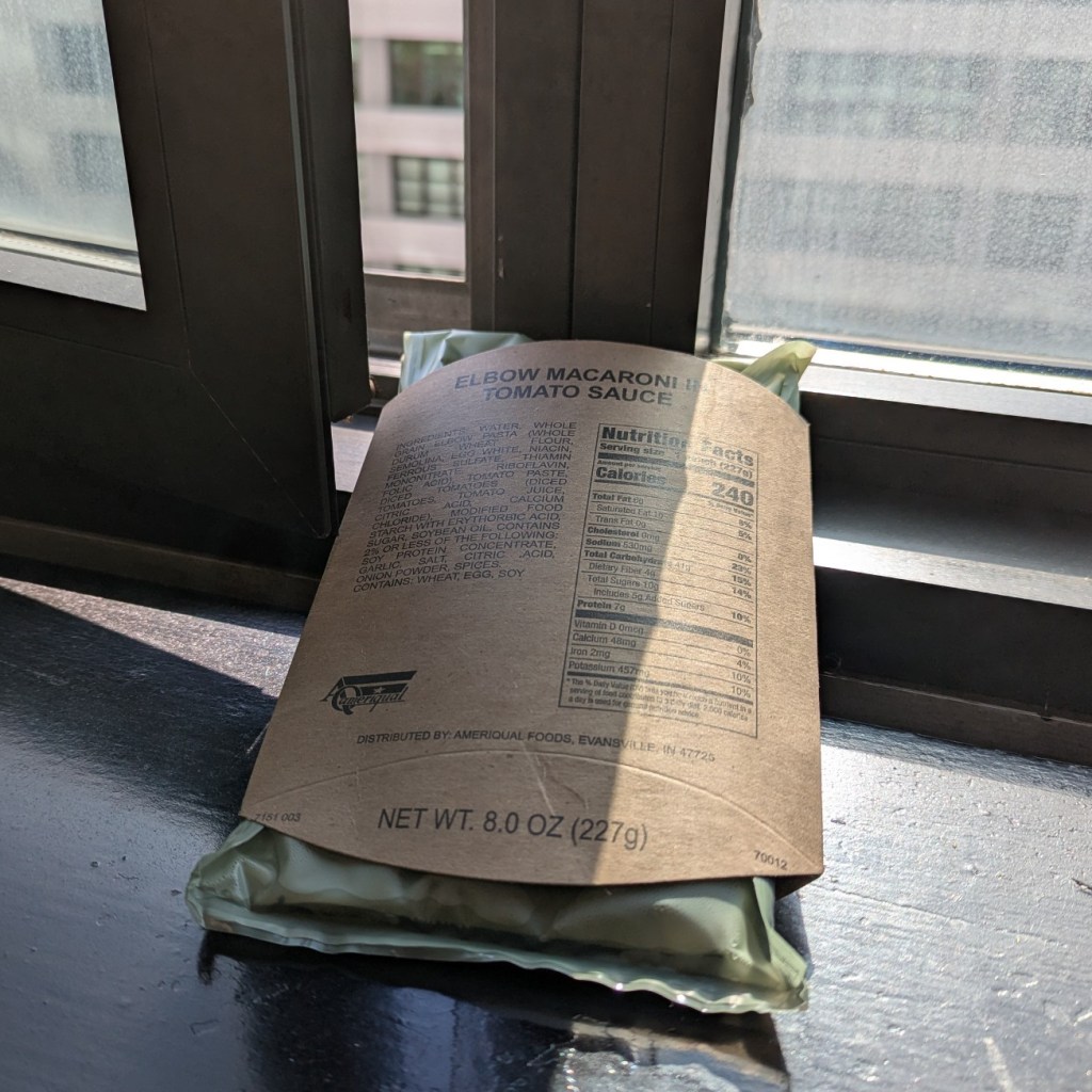 water-activated mre heater warming an elbow macaroni in tomato sauce entree inclined on a window's sill and next to open window