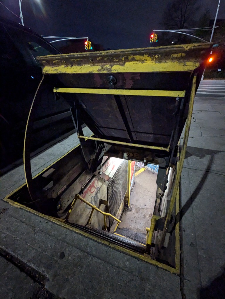 peering into the passageway under the sidewalk and the steep metal steps going down about 10 feet