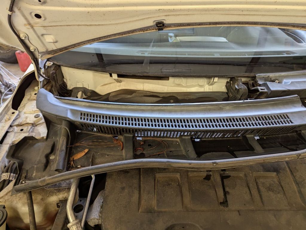 hood up on the corolla, windshield cowl on passenger side removed and pulled down