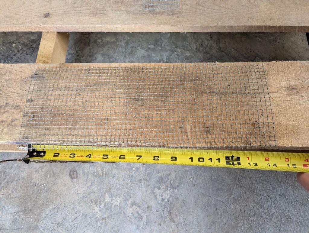 rectangular piece of wire mesh cut with ruler underneath showing 14" 