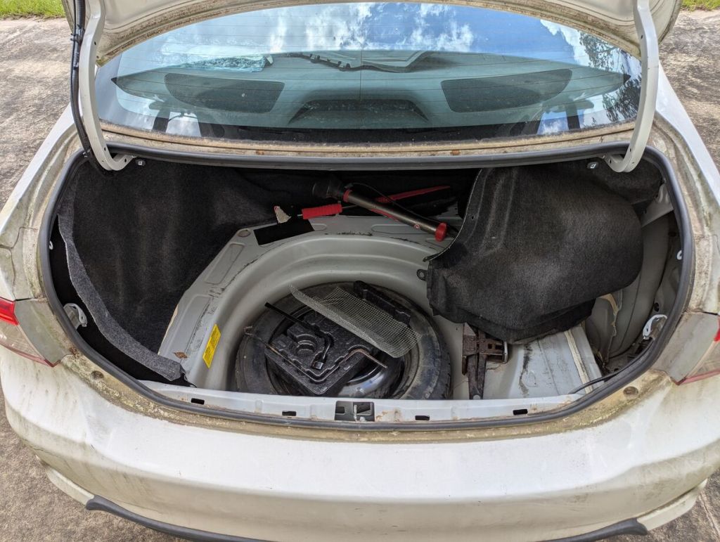 corolla trunk open with floor liner removed and upholstery on the sides pulled back