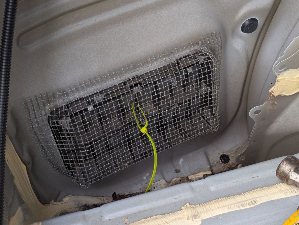 wire mesh shaped over pressure vent and secured with zip tie