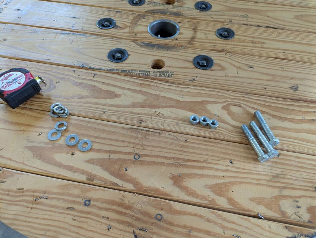 bolts, nuts, washers, and lock washers on a wood surface