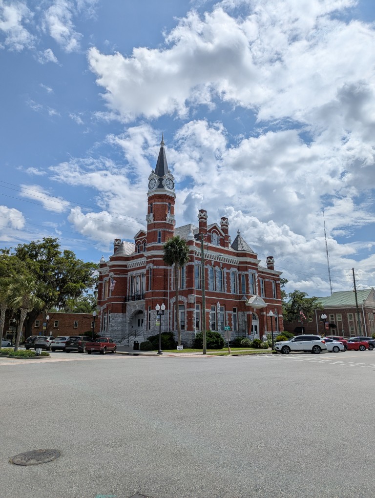 a stone and brick two story building with a spire