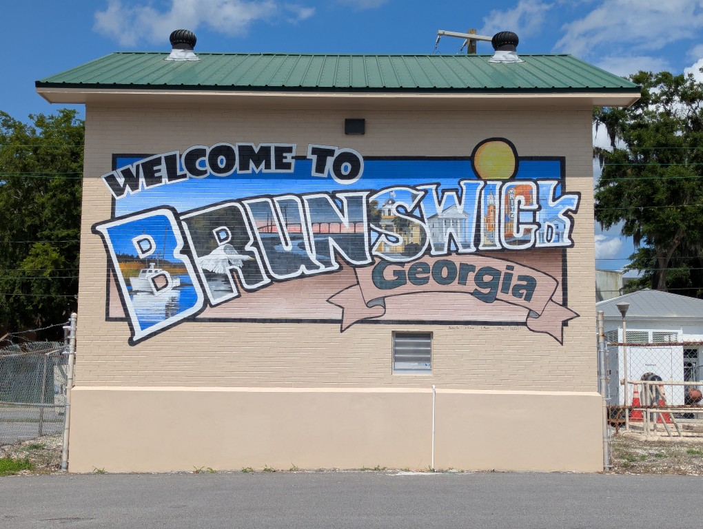 a utility building with a welcome to brunswick georgia mural painted on one side