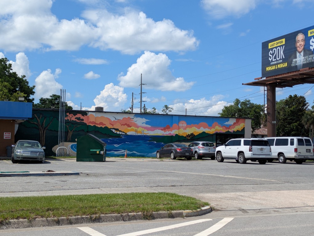 a mural of the side of the old Piddler's building showing the sound and the Sidney Lanier Bridge in the center