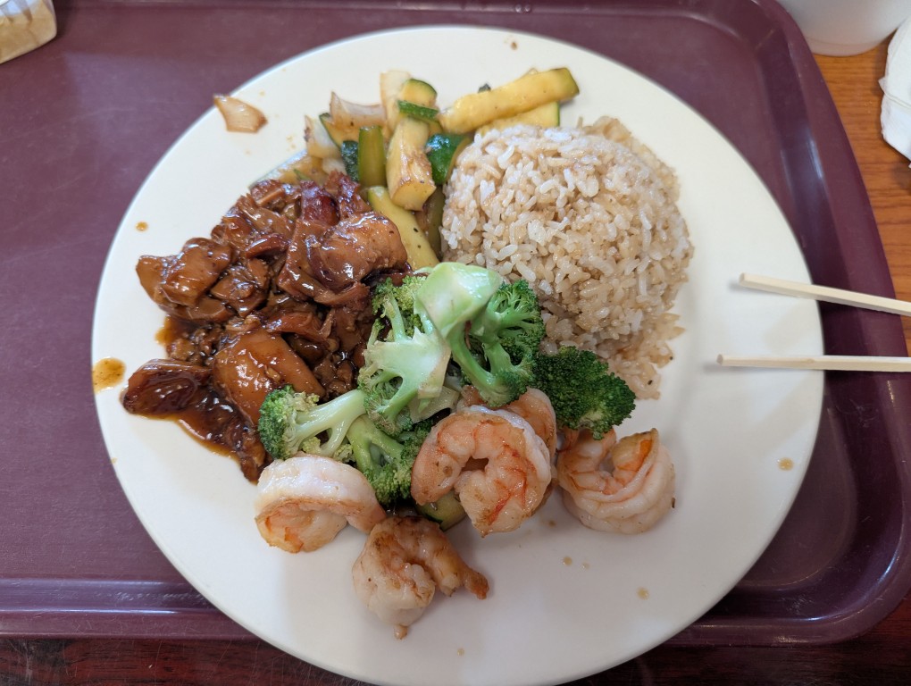 a white plate with plain fried rice, fried zucchini, teriyaki chicken, hibachi shrimp and broccoli, 
