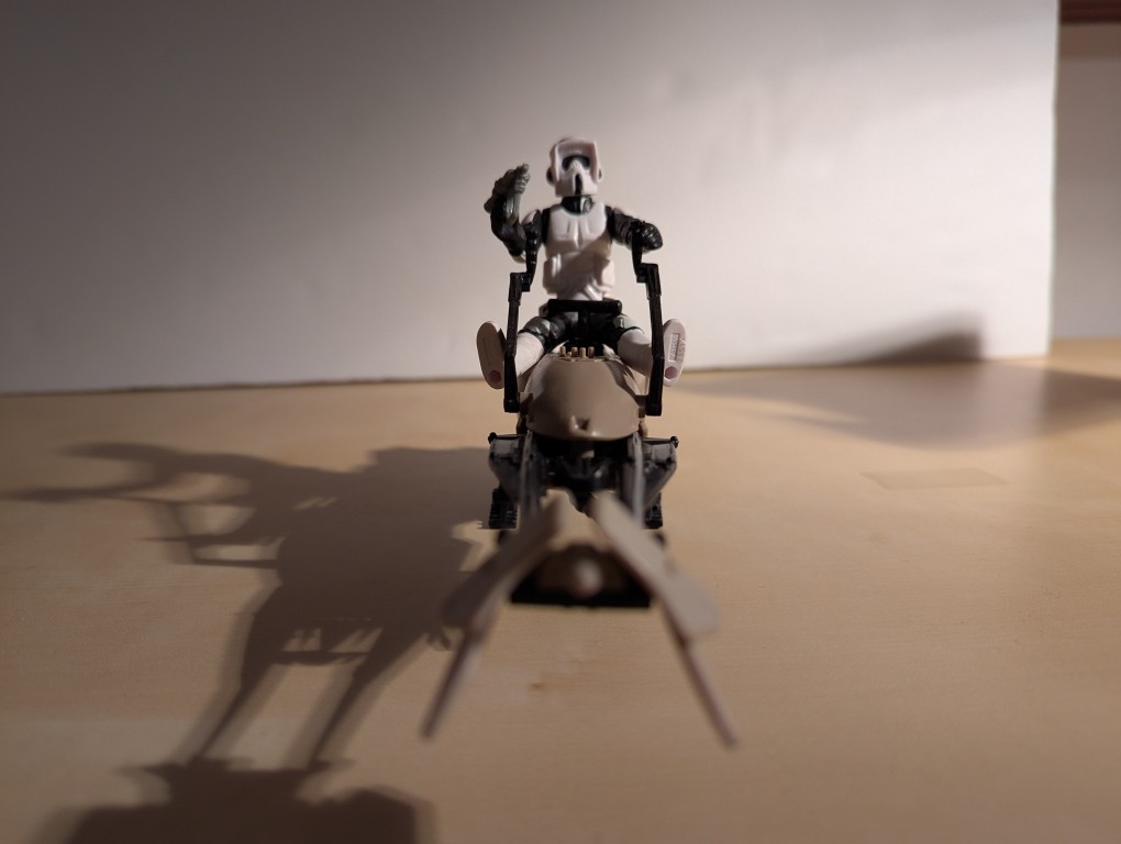 kenner speeder bike toy with a biker scout sitting on top holding the handles and a blaster pistol, front view