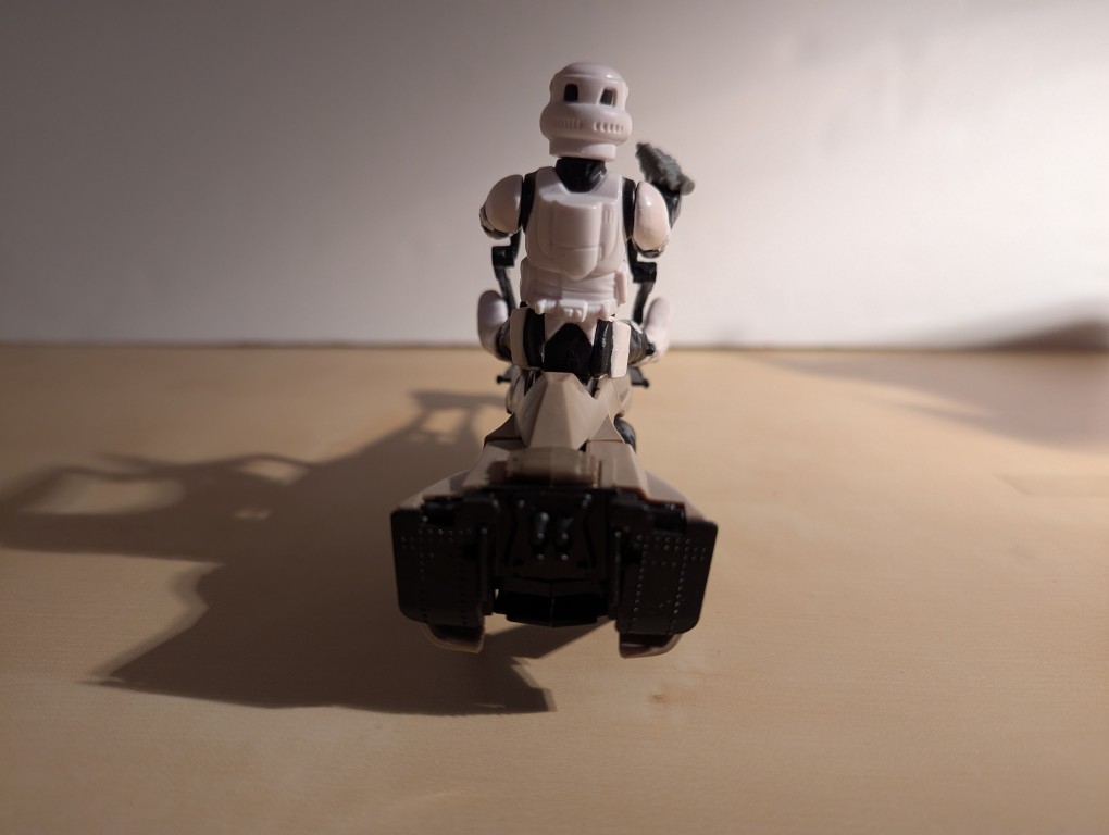 kenner speeder bike toy with a biker scout sitting on top holding the handles and a blaster pistol, rear view