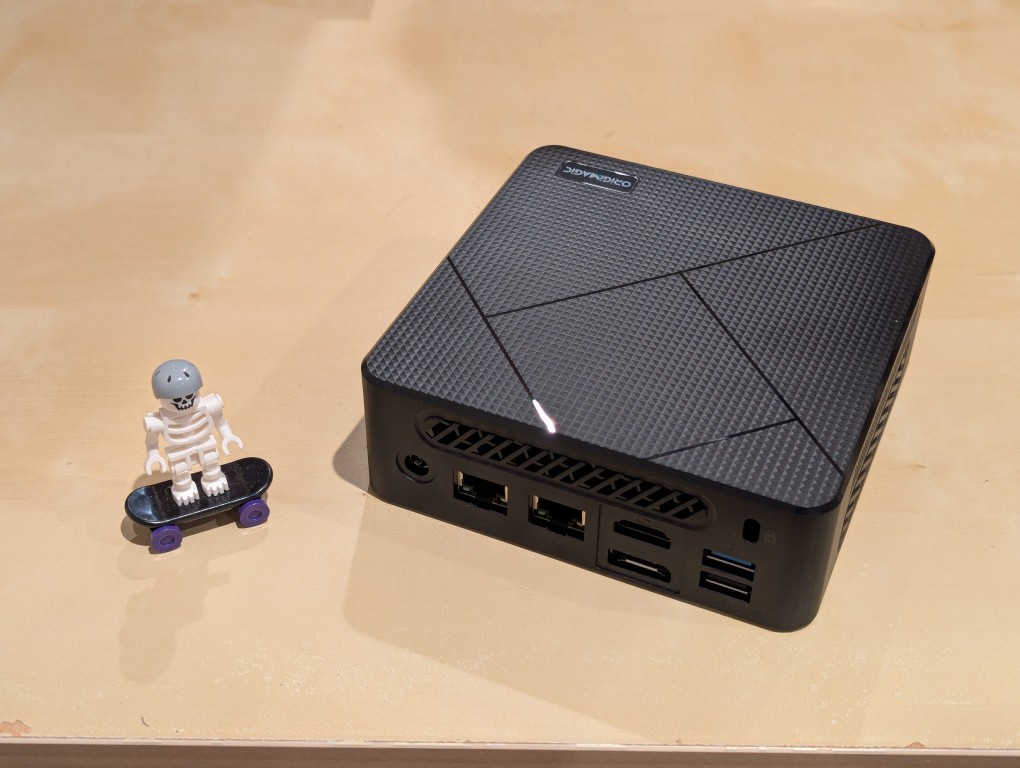 lego minifigure skeleton on skateboard next to origimagic c4 mini pc