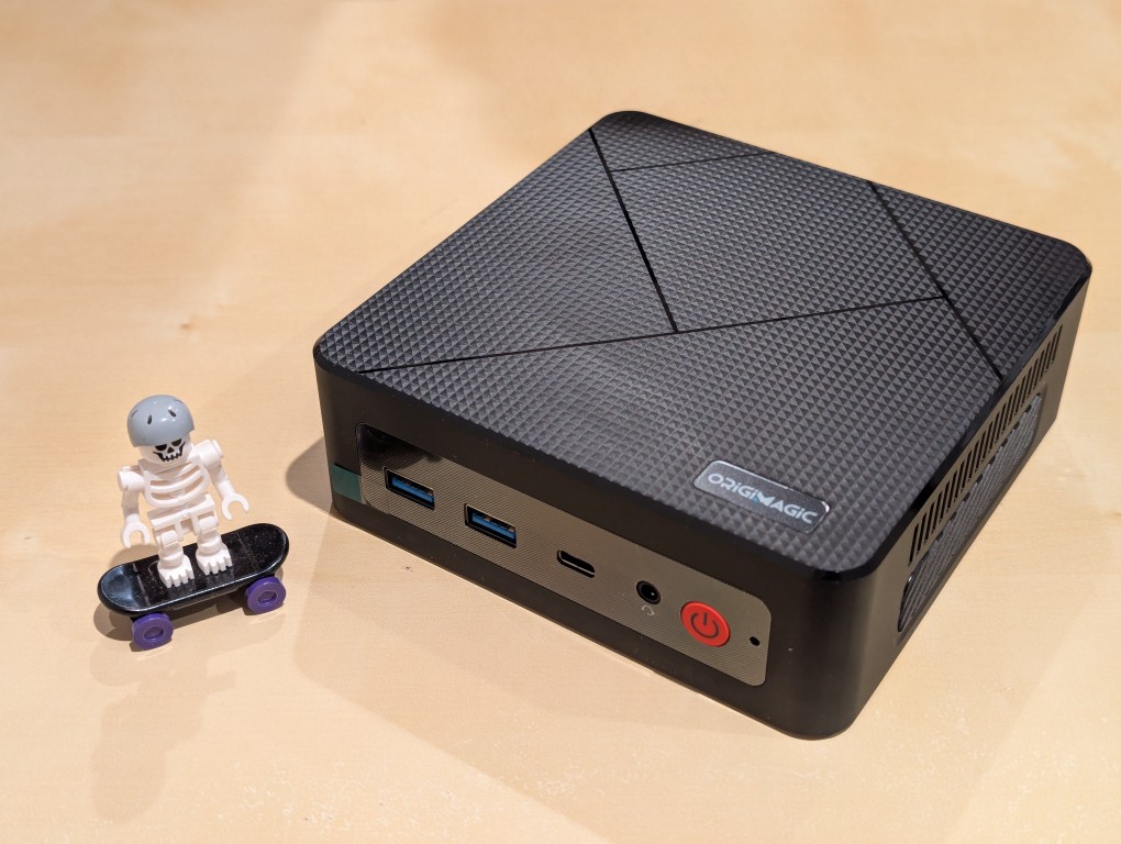 lego minifigure skeleton on skateboard next to origimagic c4 mini pc