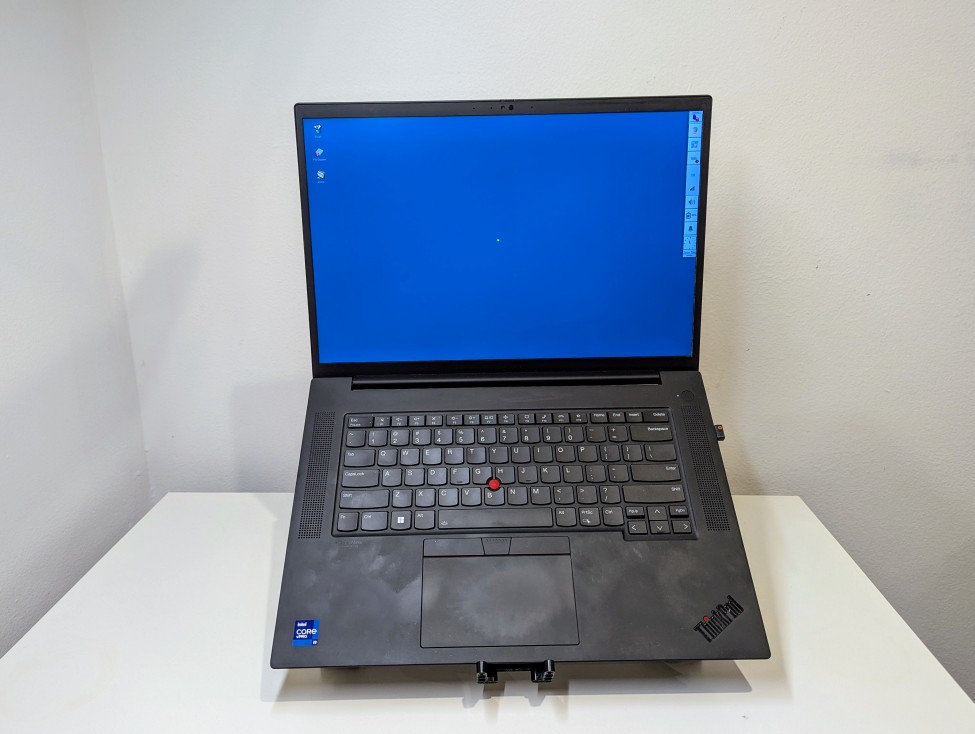 open laptop raised on a stand sitting on a white desk