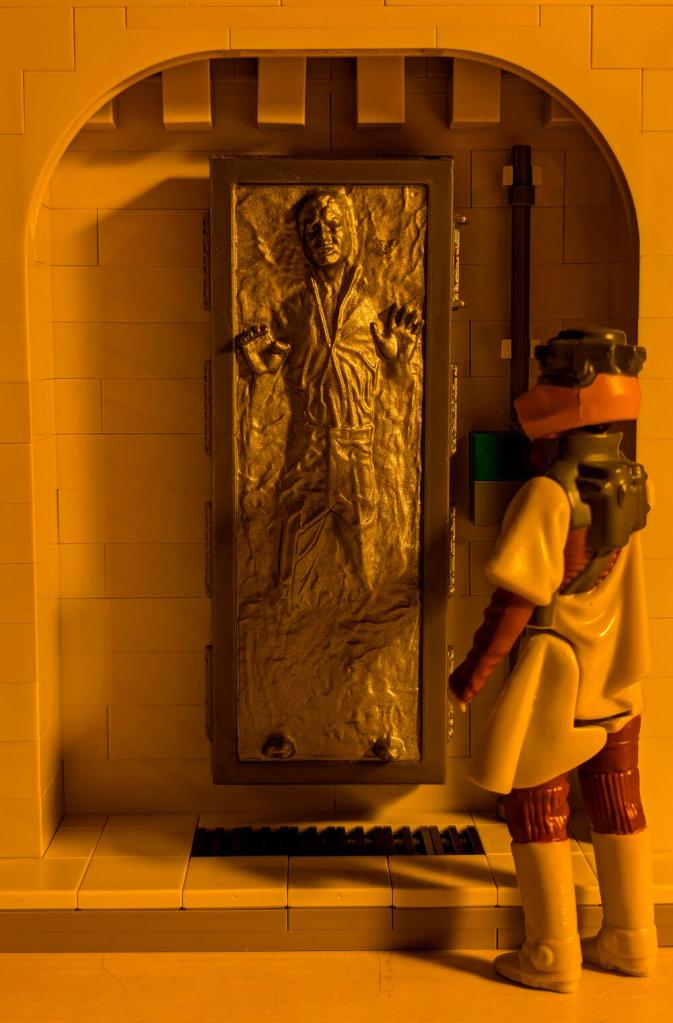Han Solo in Carbonite displayed in an alcove of Jabba's Palace built out of tan LEGO bricks.