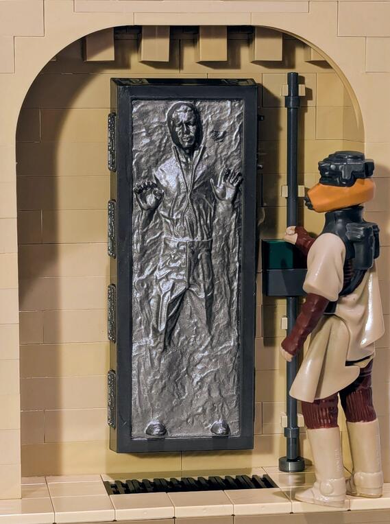 Han Solo in Carbonite displayed in an alcove of Jabba's Palace built out of tan LEGO bricks.