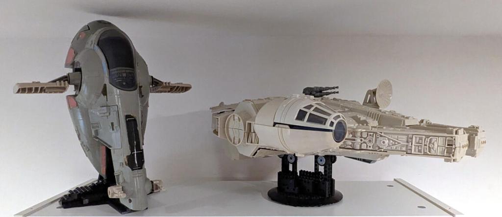 Star Wars vintage and modern action figures and vehicles on a bookshelf and desk.