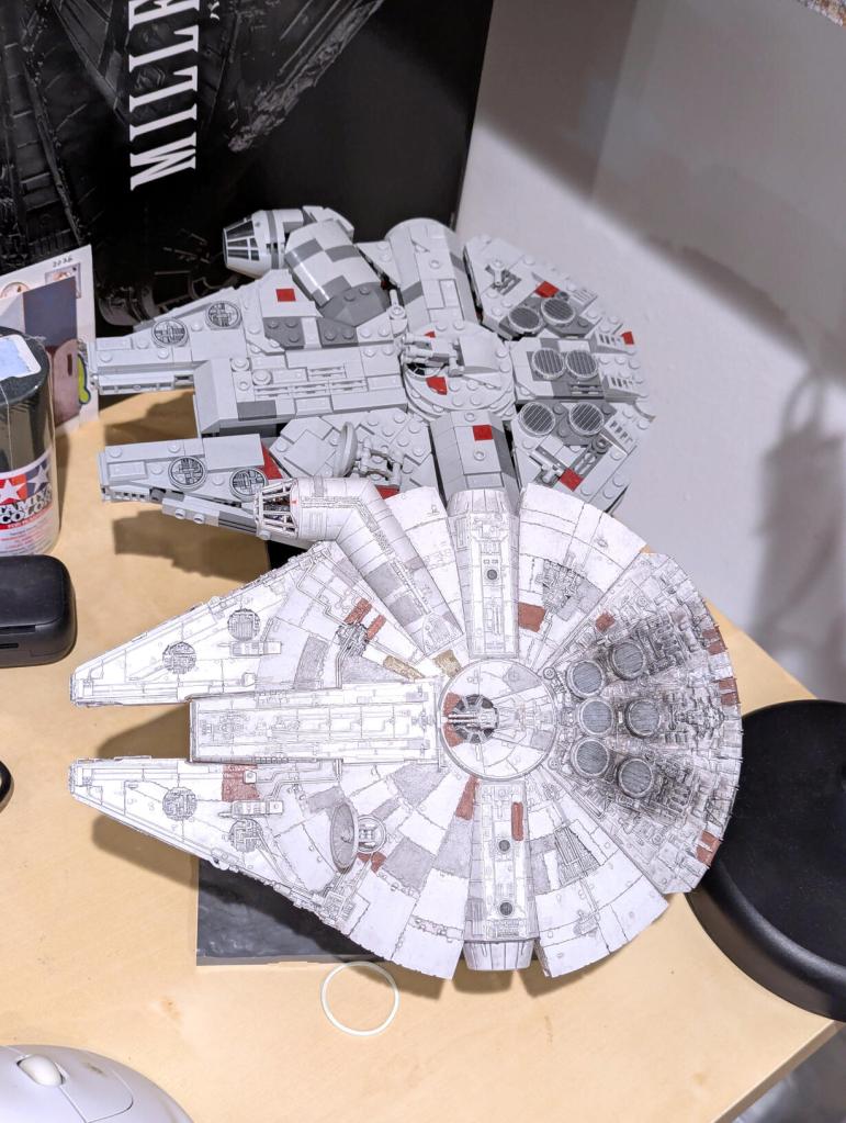 Star Wars vintage and modern action figures and vehicles on a bookshelf and desk.